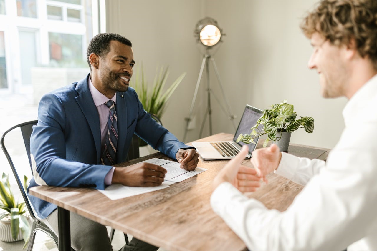 Two men at a table discussing moving insurance and liability