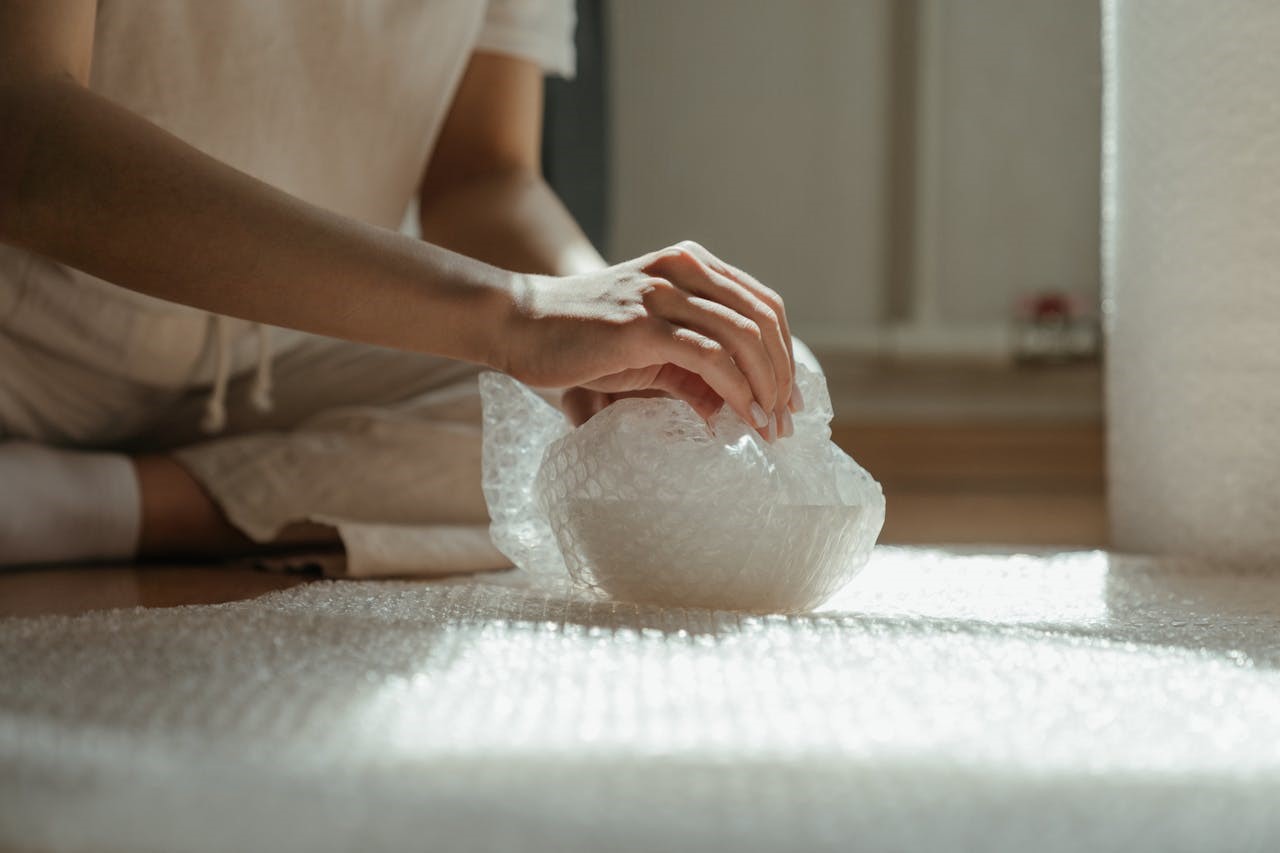 A woman unwrapping a bubble-wrapped bowl